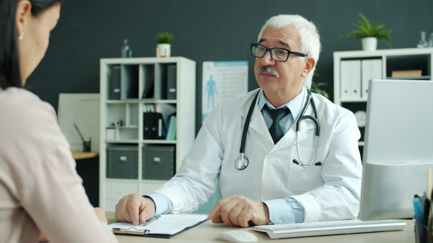 A doctor listening to a patient during an appointment